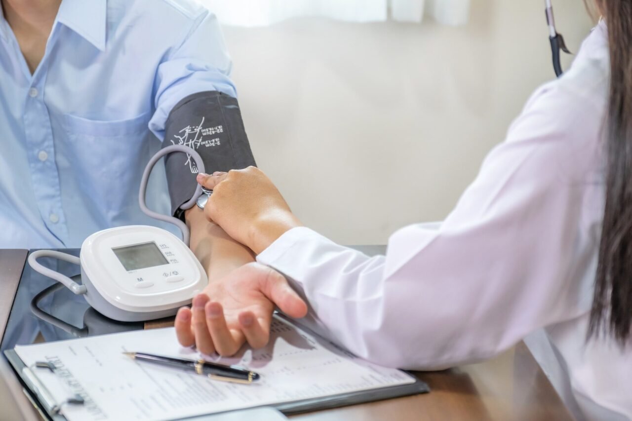 doctor examines the patient s pulse with stethoscope and records the results health medical checkup.jpg